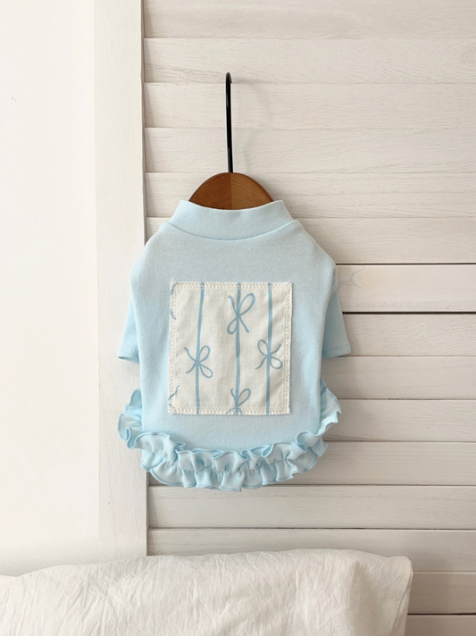 Front view of blue ruffle pet shirt with floral patch